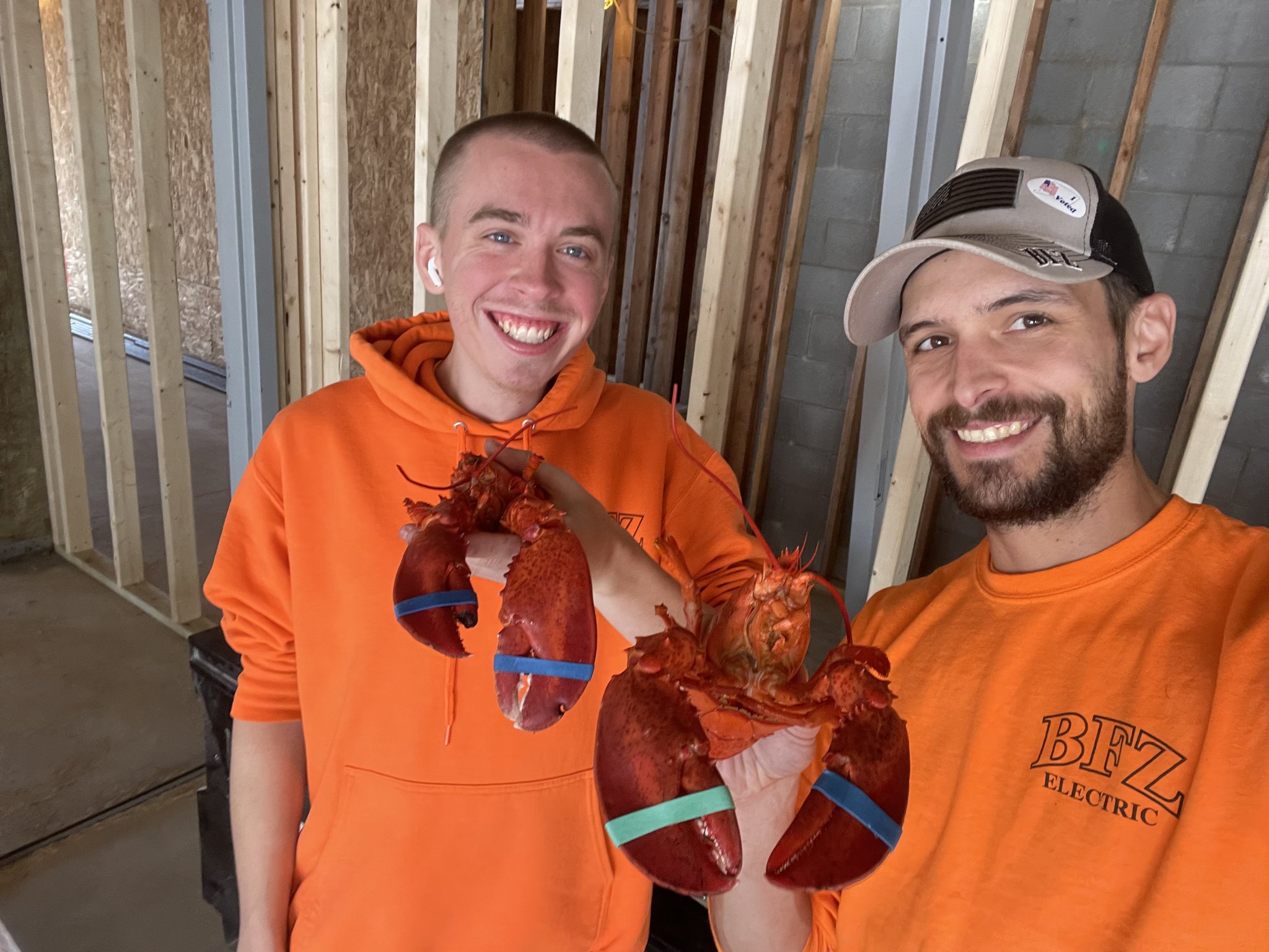 BFZ Electric team members holding lobsters on a jobsite